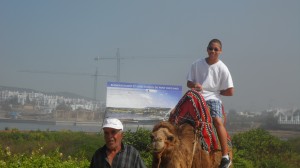 Chris Dennis riding a camel while studying in Morocco